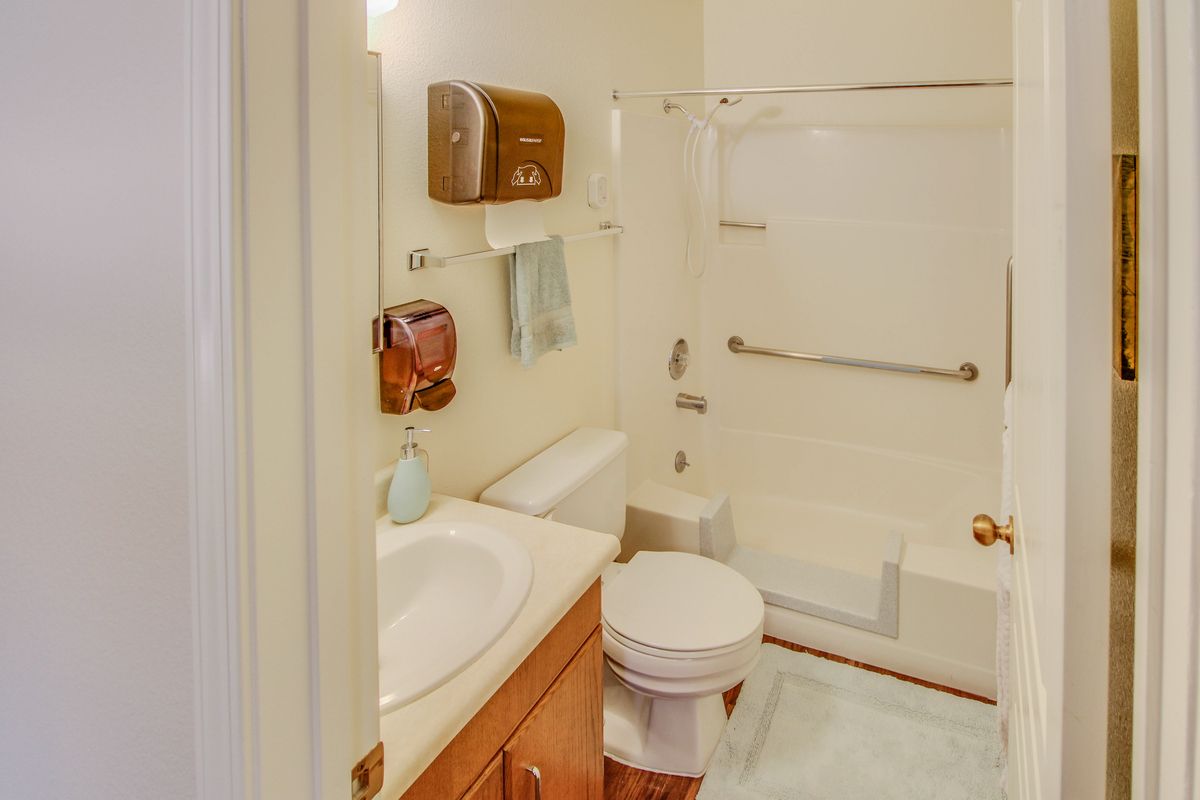 A compact bathroom featuring a sink, toilet, and bathtub with shower.