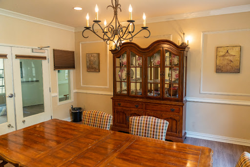 A beautifully arranged dining room featuring a wooden table, checkered chairs, and an elegant chandelier.
