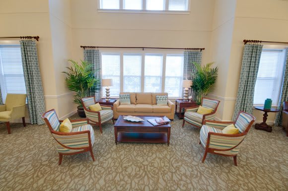 A cozy living room with seating area and large windows.