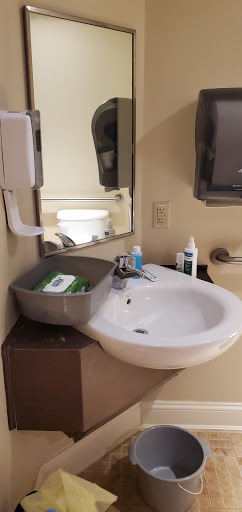 A clean bathroom sink area with personal care items and a mirror.
