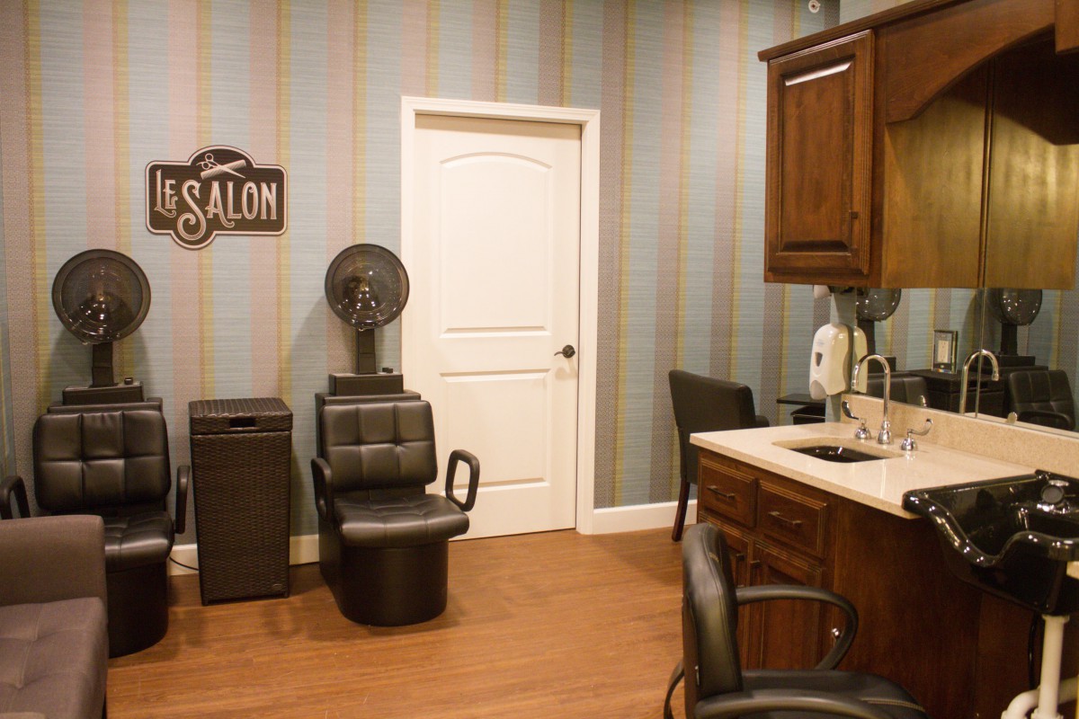 Interior of a hair salon with a styling chair and hairdryer.