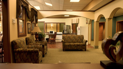 A cozy and inviting living space with patterned sofas and a view of the kitchen area.