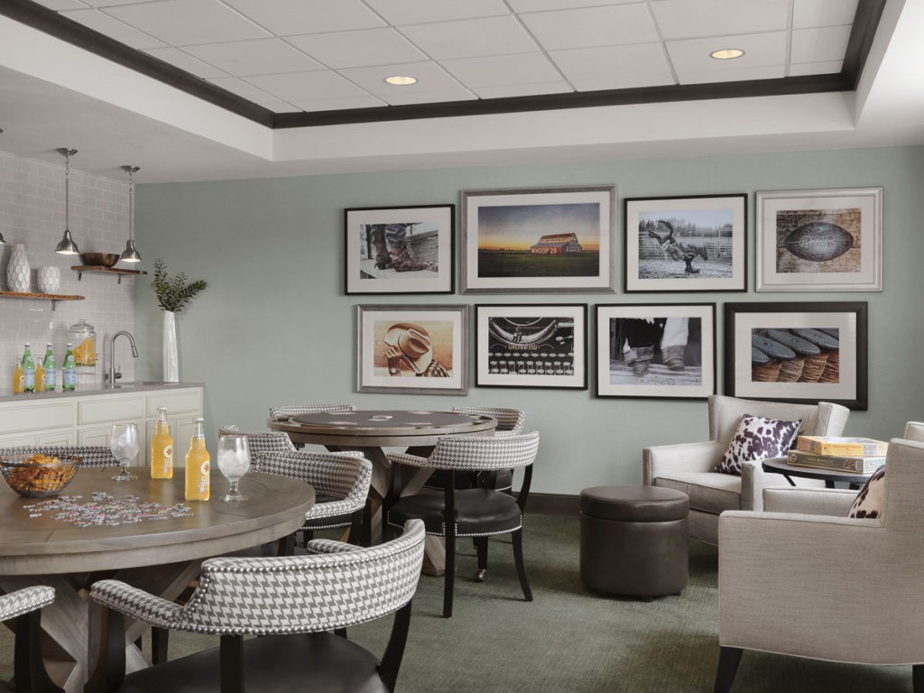 A modern lounge area featuring comfortable seating and artwork on the walls.