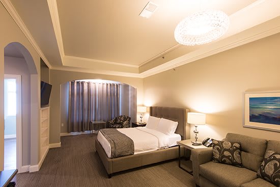 A modern hotel room with a comfortable bed, stylish furniture, and soft lighting.