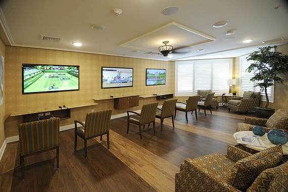 A modern lounge featuring multiple televisions and comfortable seating.