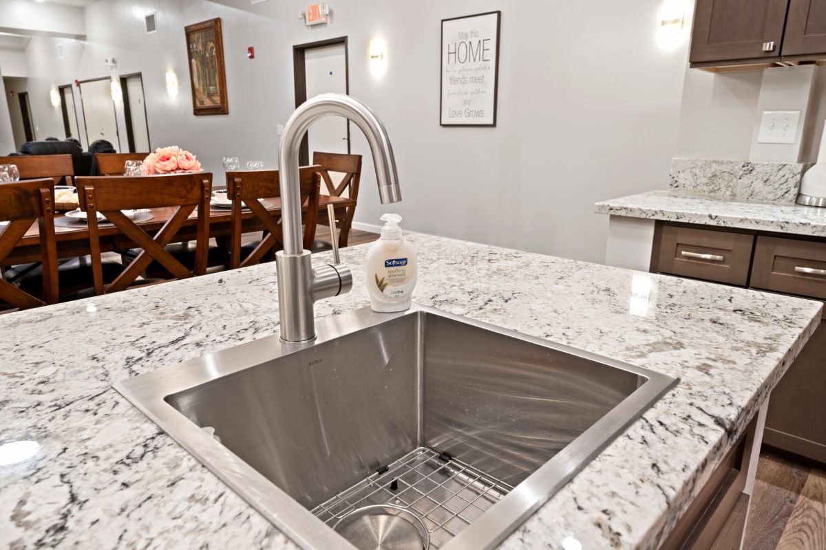 A modern kitchen with a stainless steel sink and elegant countertop.