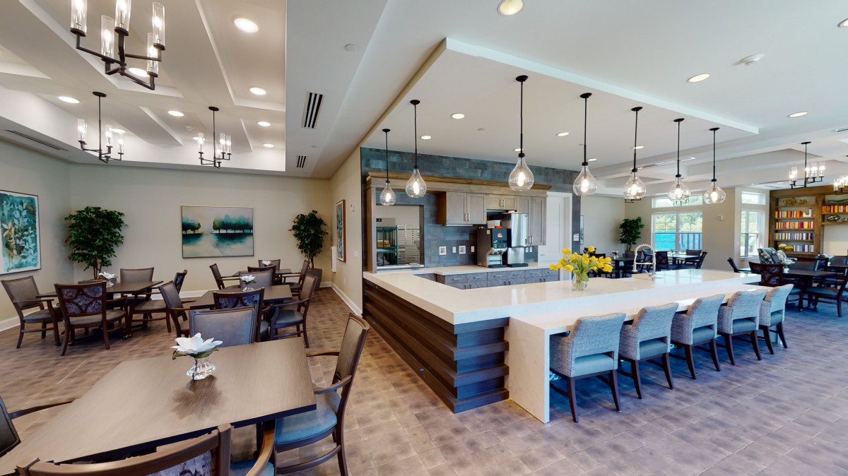 A modern kitchen with an adjacent dining area featuring sleek design and contemporary furnishings.