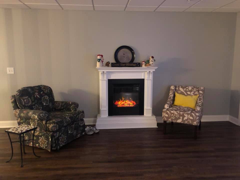 A cozy living room with a fireplace and two comfortable chairs.
