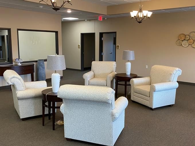 A cozy lobby seating area with armchairs and lamps.