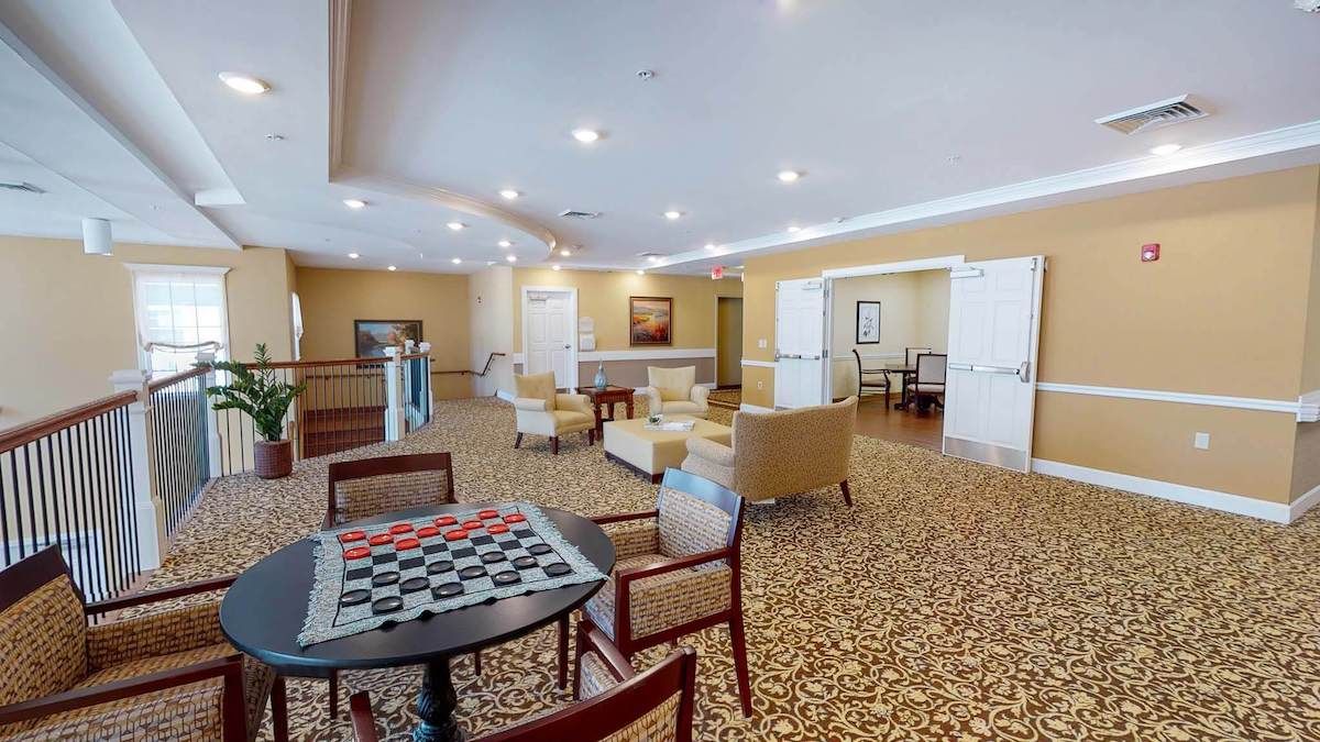 A spacious lounge area with comfortable seating and a game table.