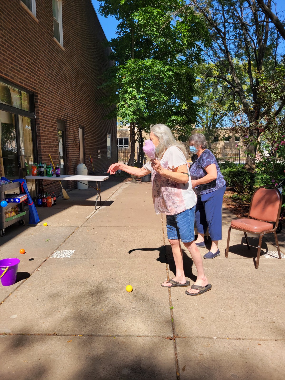 Seniors enjoying an outdoor game of toss on a sunny day.