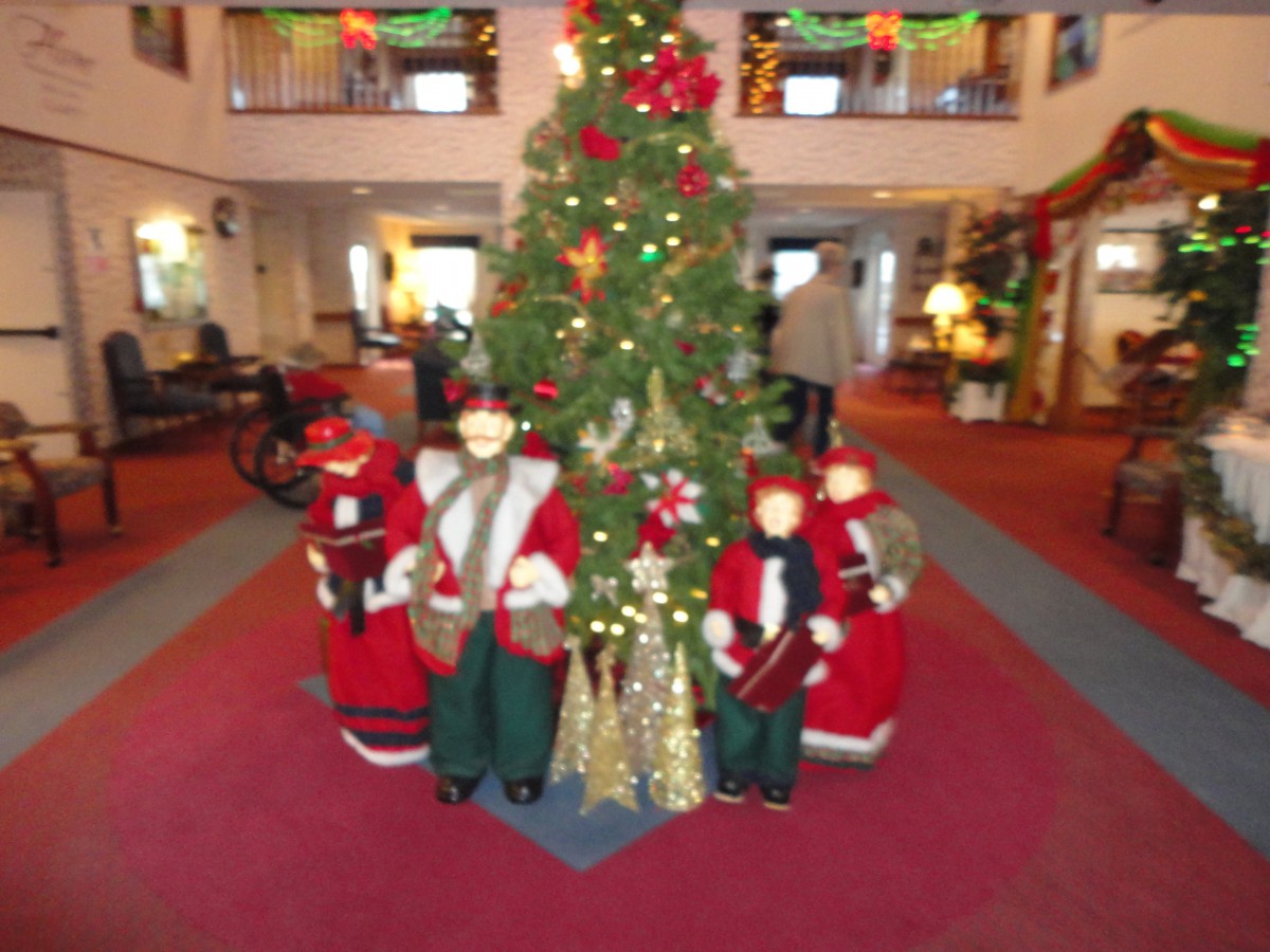 A festive Christmas tree surrounded by holiday decorations indoors.
