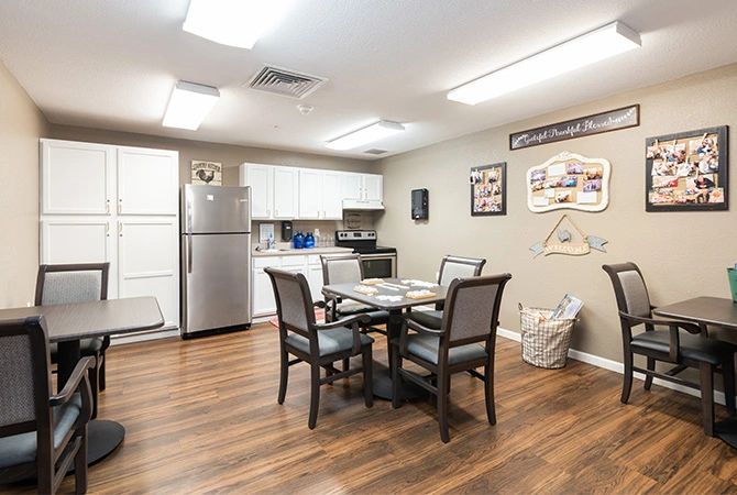 A modern kitchen and dining area with a table, chairs, and appliances.