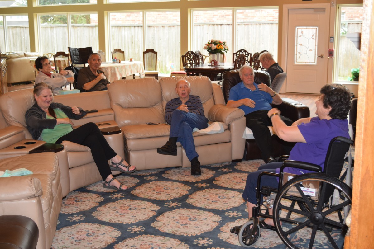A group of seniors socializing in a comfortable living room setting.