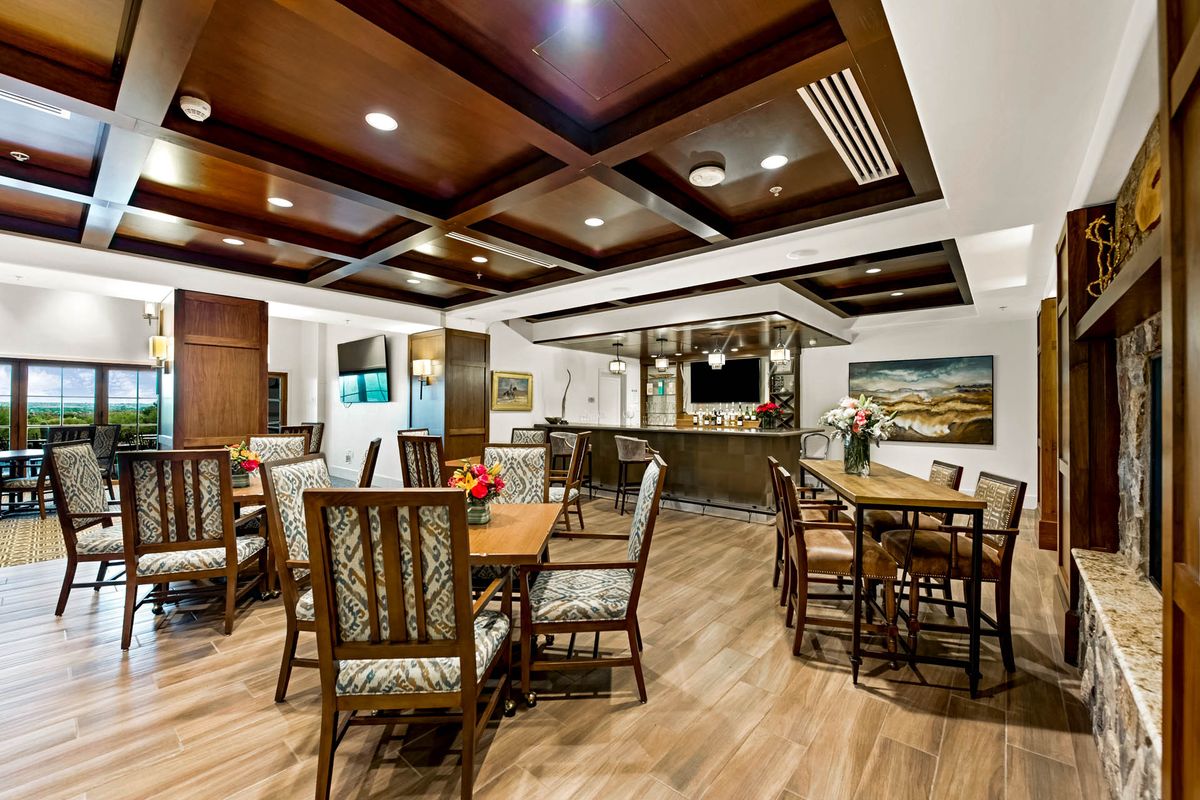 A modern dining area with wooden furniture and elegant lighting.