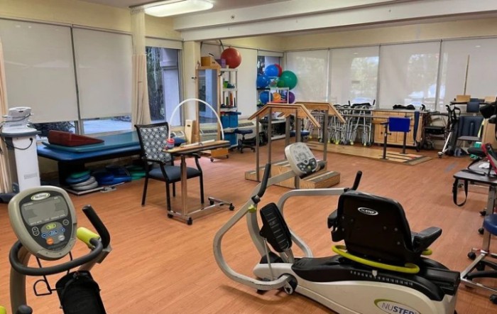 A well-equipped physical therapy room with various exercise machines and rehabilitation tools.