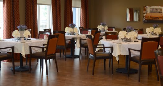 An elegant restaurant dining room with neatly set tables and chairs, ready for guests.