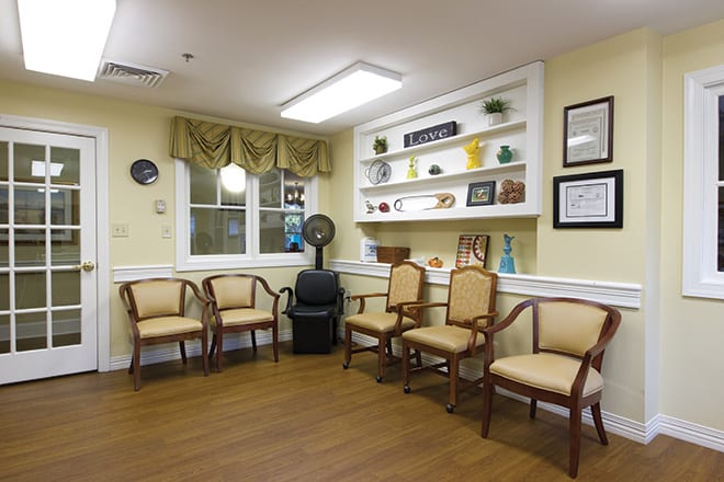 A cozy waiting room with chairs arranged along the wall and decorative shelves.