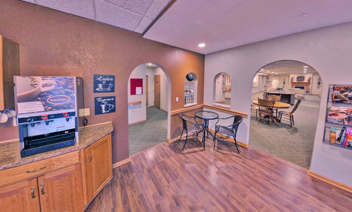 A cozy office reception area with wooden flooring and seating.