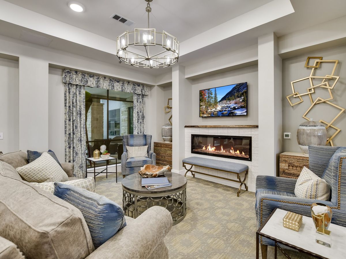 A modern living room with elegant decor, featuring a cozy fireplace and comfortable seating.