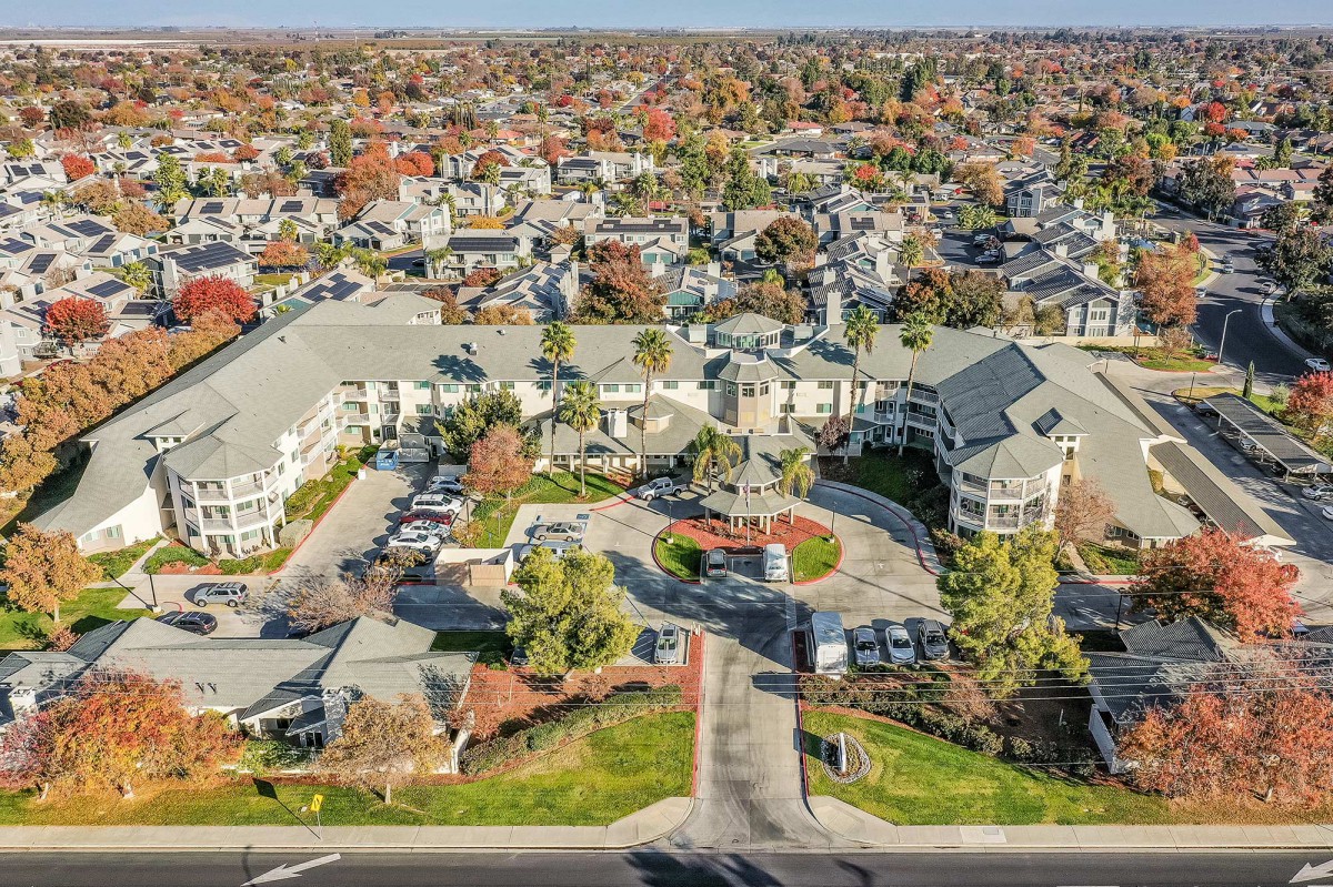 Aerial view of a sprawling residential suburb with tree-lined streets during autumn.