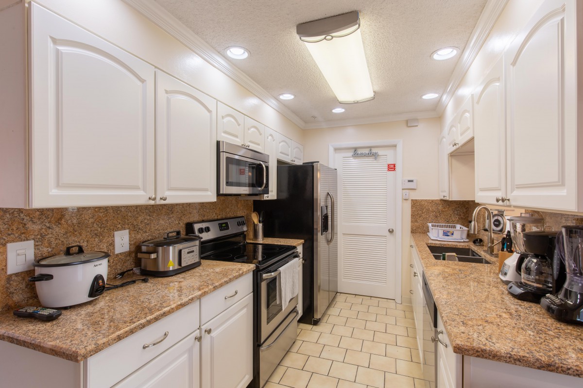 A modern kitchen with stainless steel appliances and white cabinetry.