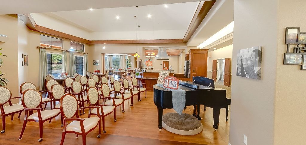 A spacious music room with a grand piano and neatly arranged chairs.