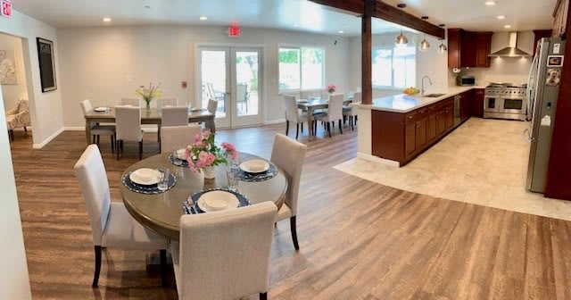 A spacious, modern open-plan dining and kitchen area with elegant decor and ample natural light.