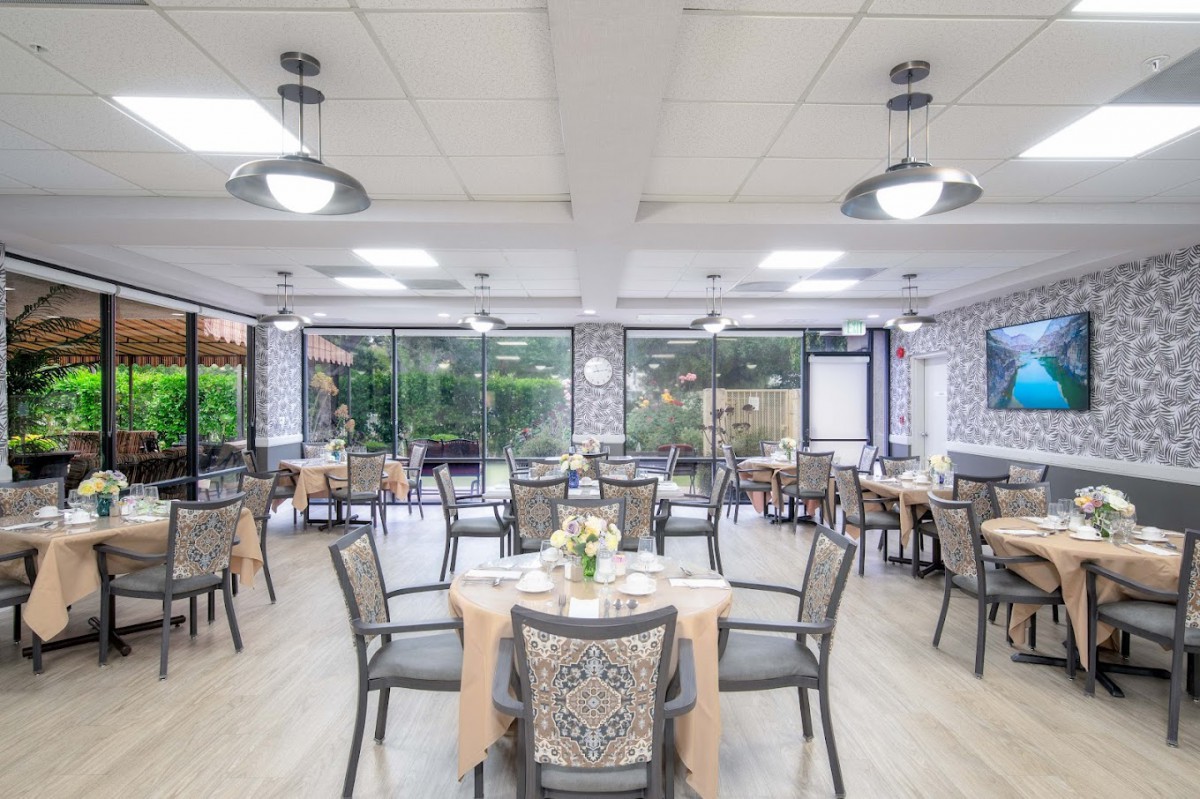 A well-lit restaurant dining area with neatly arranged tables and chairs.