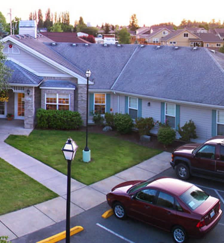 A suburban house with parked cars in the driveway.