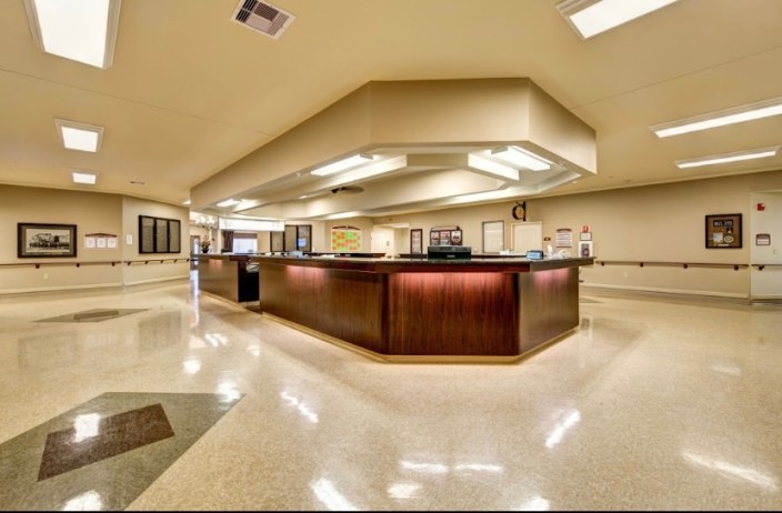 A spacious reception area with a central desk and bright lighting.