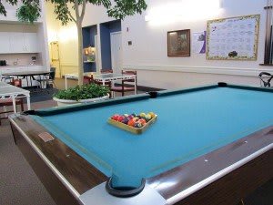 A billiards table set up in a recreation room with a rack of balls ready for play.