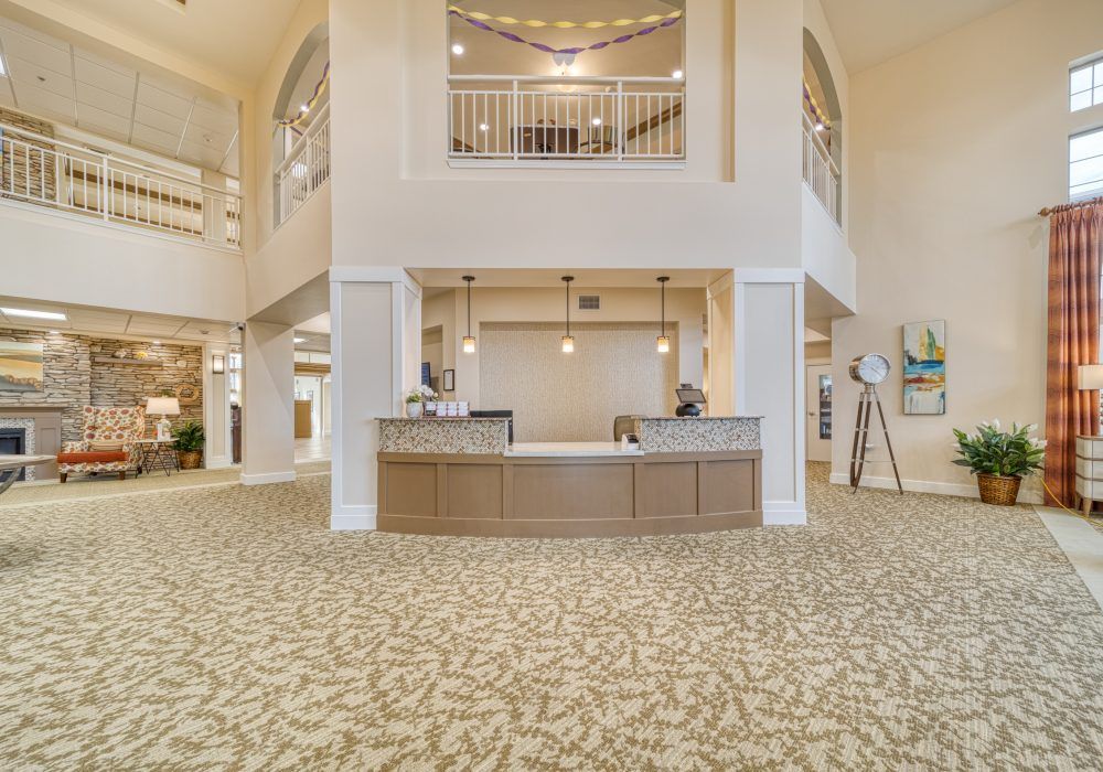 A spacious and elegantly designed hotel lobby with a central reception desk, modern lighting, and stylish decor.