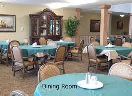 A well-arranged dining room with multiple tables covered in teal tablecloths.