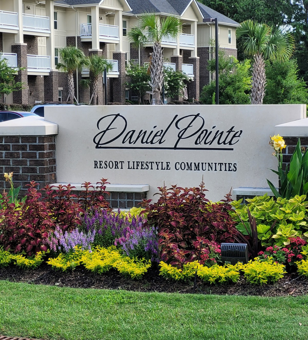 Entrance sign of an apartment complex with well-maintained landscaping.