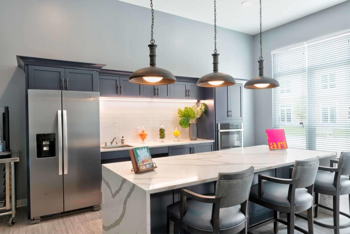 A modern kitchen with an island counter and pendant lighting.