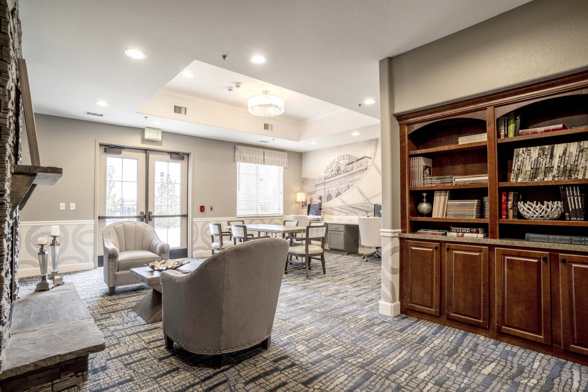 A modern lobby with comfortable seating and a bookshelf.