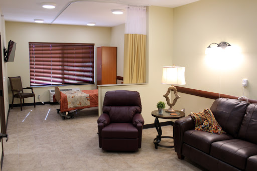 A well-designed hospital patient room featuring comfortable seating and warm lighting.