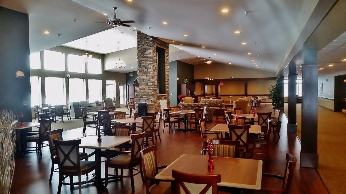 An empty restaurant interior with wooden tables and chairs, showcasing a modern and open design.