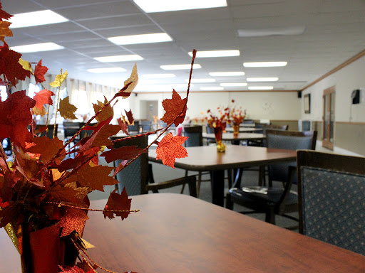 A cozy dining area adorned with autumn-themed decor, featuring tables and chairs ready for guests.
