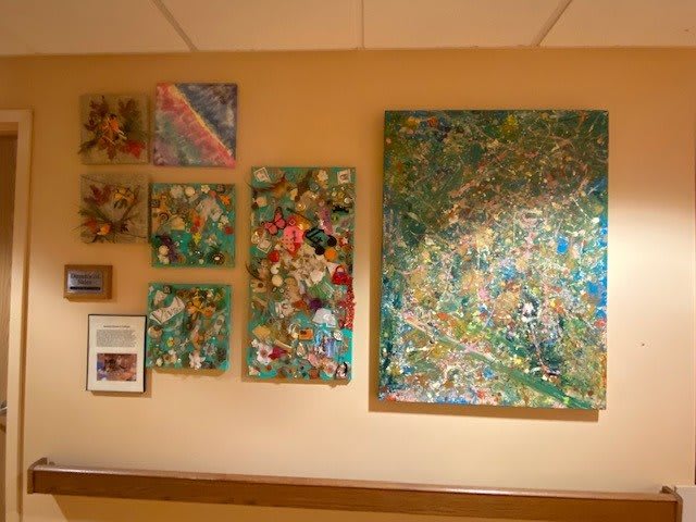 A collection of colorful abstract paintings displayed on a wall.
