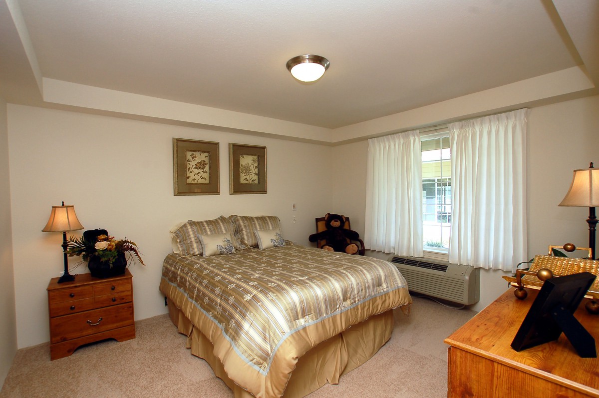Cozy bedroom with a plaid bedspread and natural light.