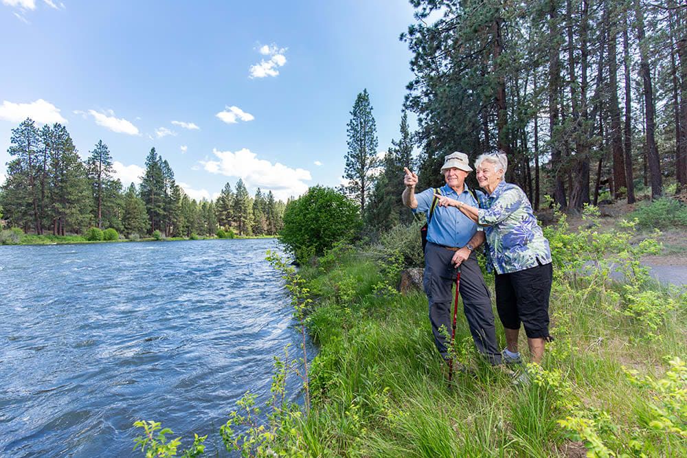 A couple enjoying a scenic hike alongside a river.