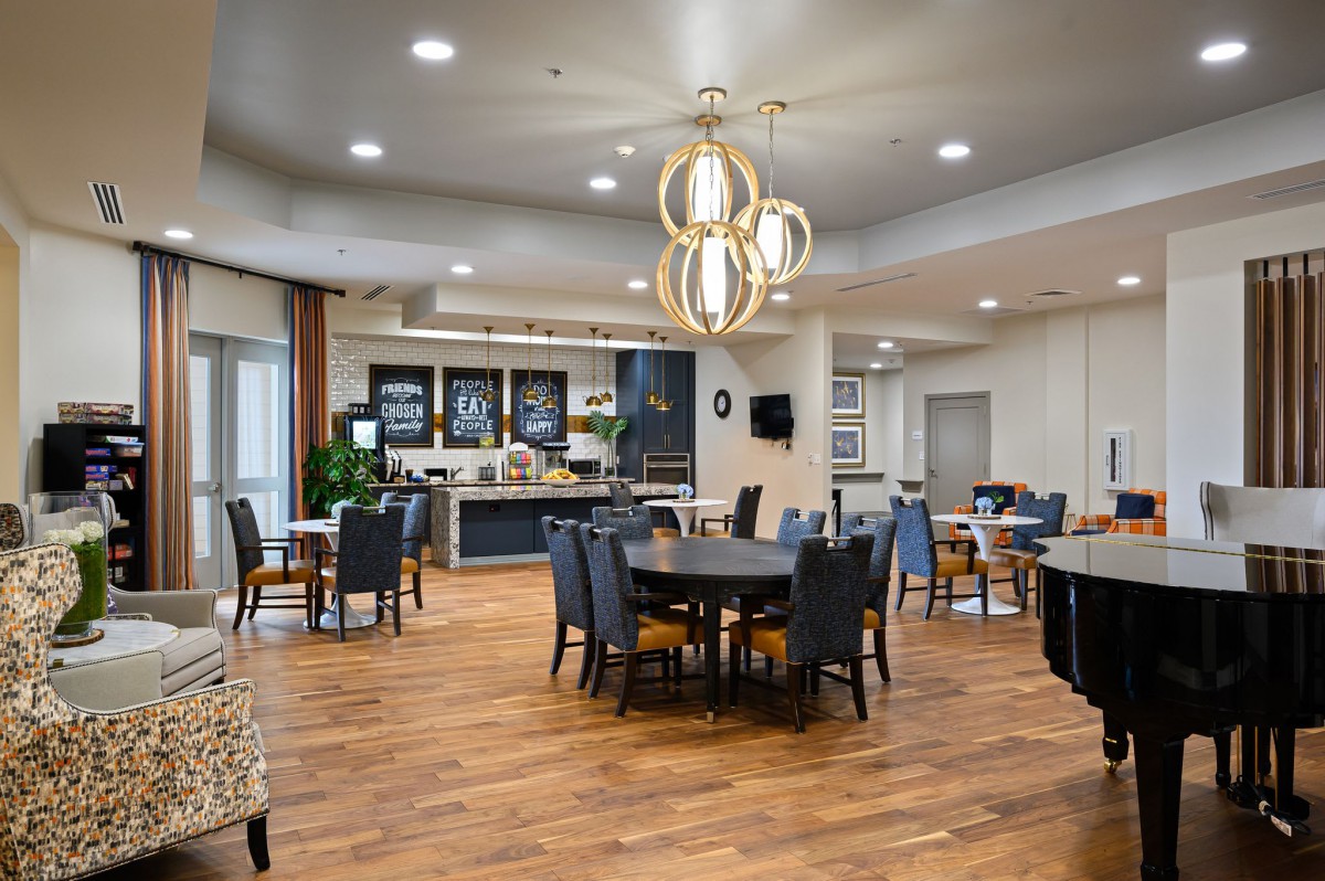 A modern dining area with elegant lighting and wooden flooring.