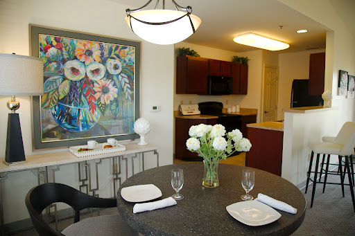 A stylish and inviting dining room featuring a modern table setting, floral centerpiece, and vibrant artwork.