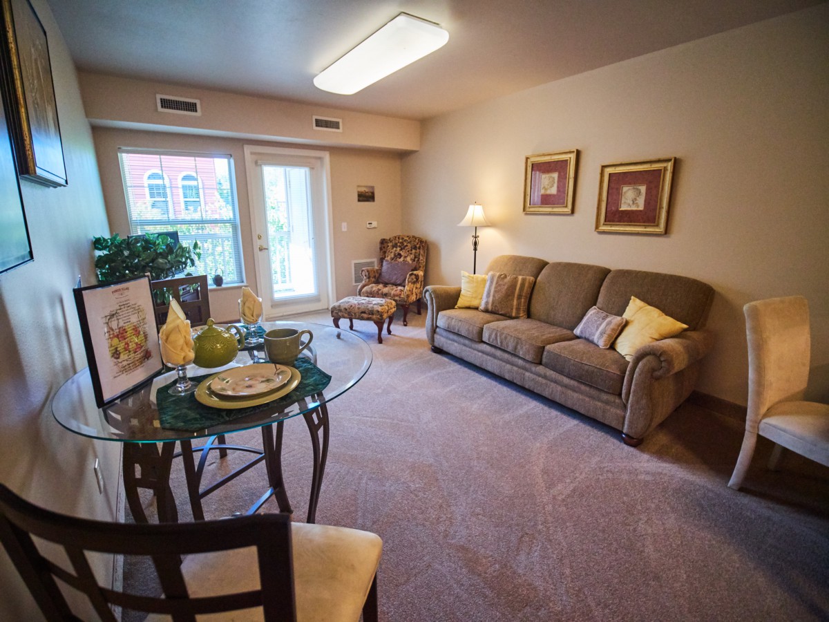 A cozy living room with a sofa, armchair, and decorative elements.