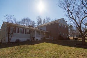 A suburban house with a brick exterior on a sunny day.