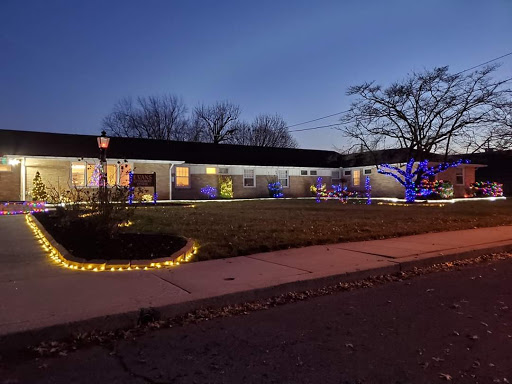 A beautifully decorated house illuminated with colorful lights during the evening.