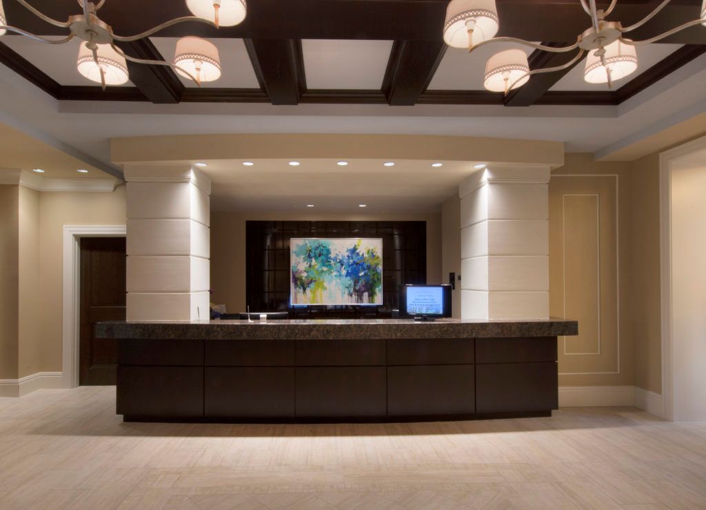 A modern hotel reception area with a check-in desk and decorative artwork.