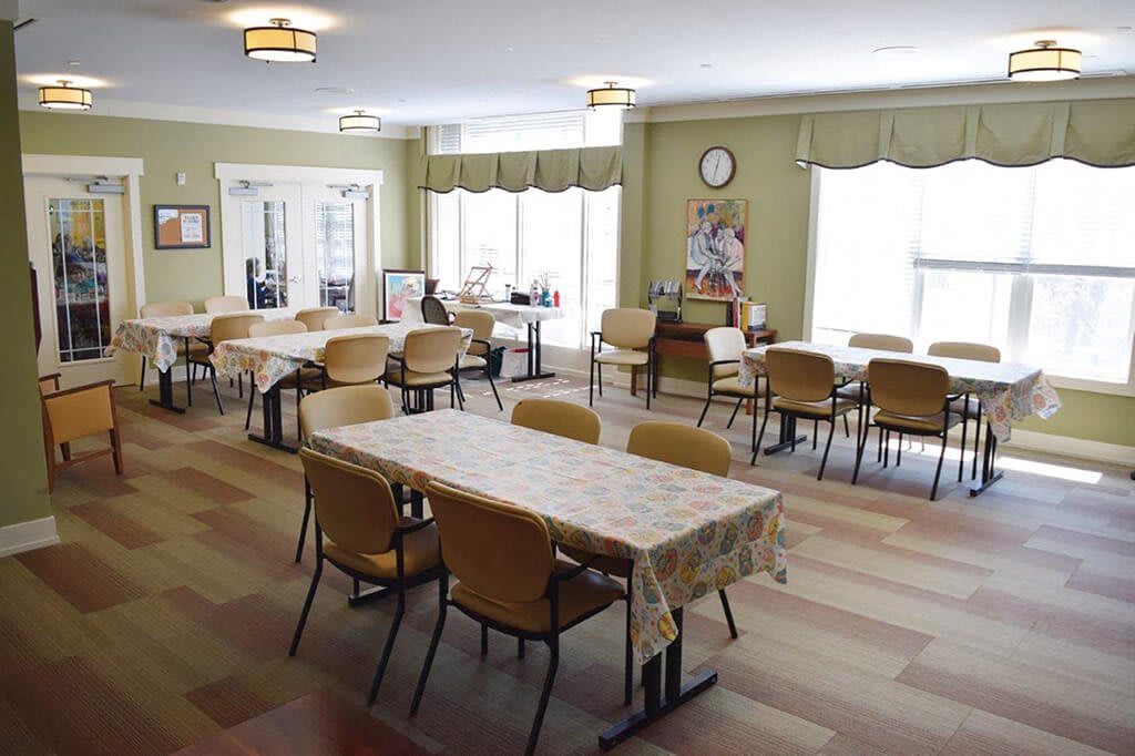 An empty dining hall with neatly arranged tables and chairs, ready for guests.